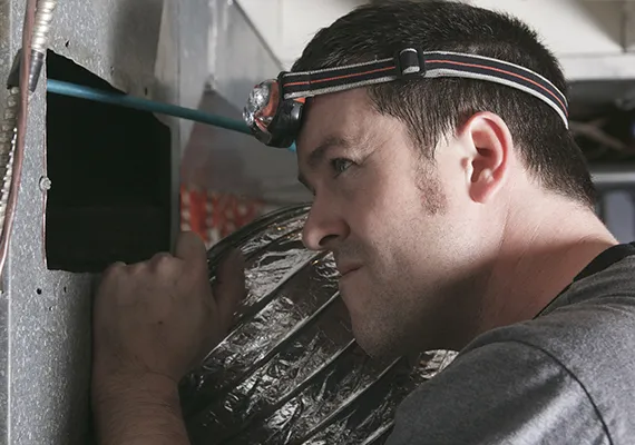 Technician conducting detailed inspection of an air duct system to ensure proper installation and functionality in Lafayette, GA.