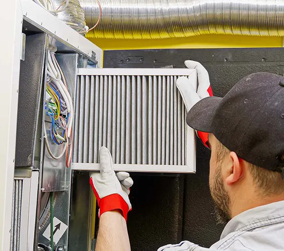 A technician working on an HVAC unit with a focus on emergency repair services.