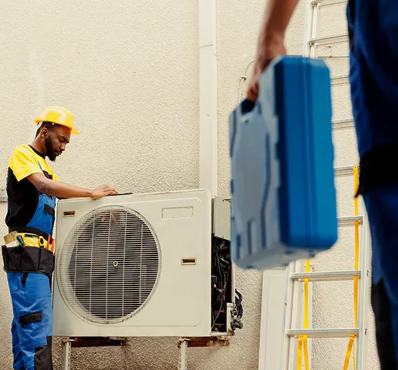 Technician performing an HVAC tune-up service on an outdoor unit.